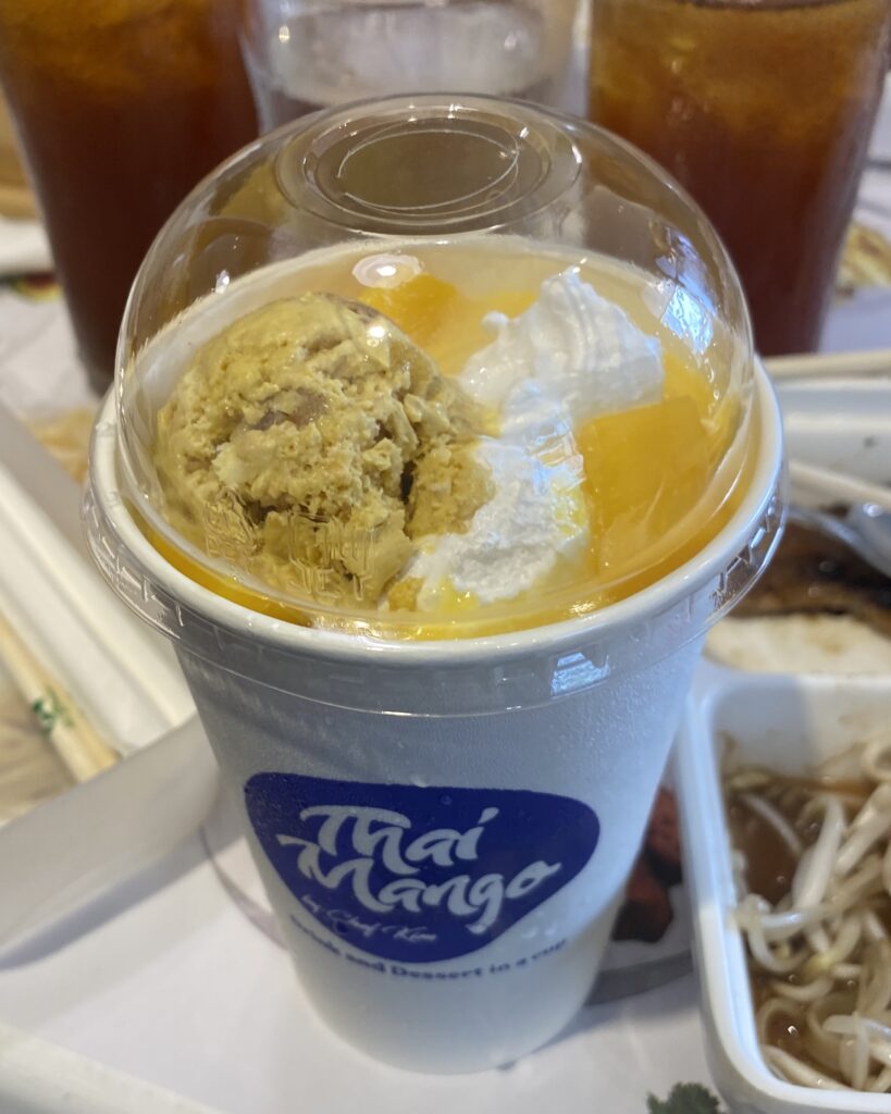 Thai Mango Classic smoothie with fresh mango slices, whipped cream, and homemade ice cream