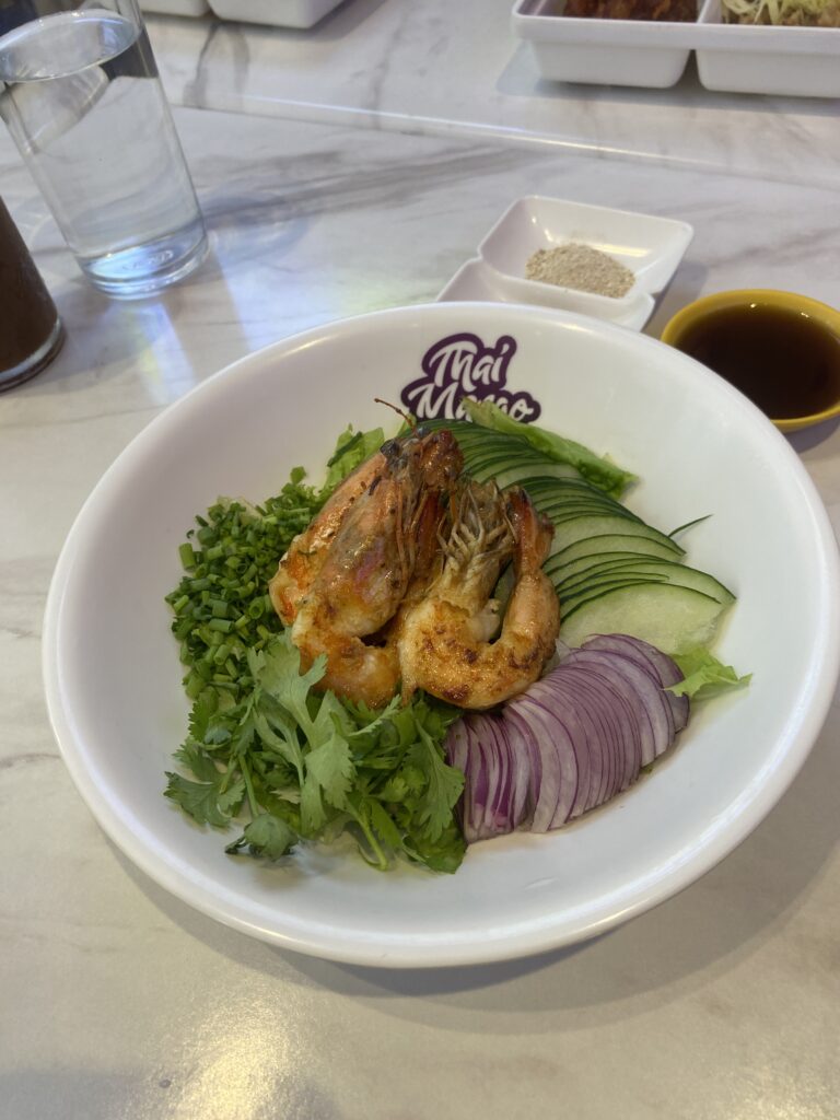Shrimp salad featuring pan-fried shrimp, fresh vegetables, and light Thai dressing